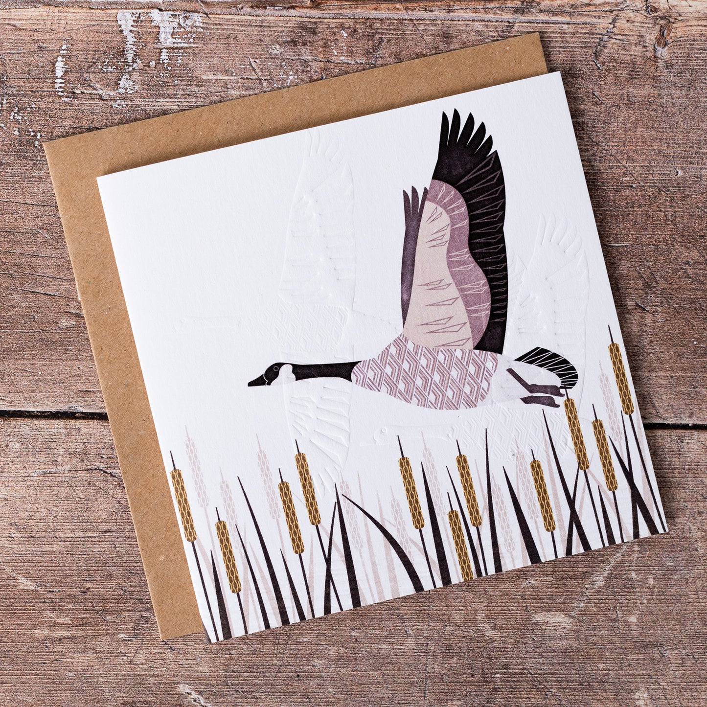 This high quality, linocut printed, Canada Goose card has been handcrafted by the talented Ashley Hutchinson in his rural West Sussex garden studio. This design features a Canada Goose flying above reeds on an embossed card background.