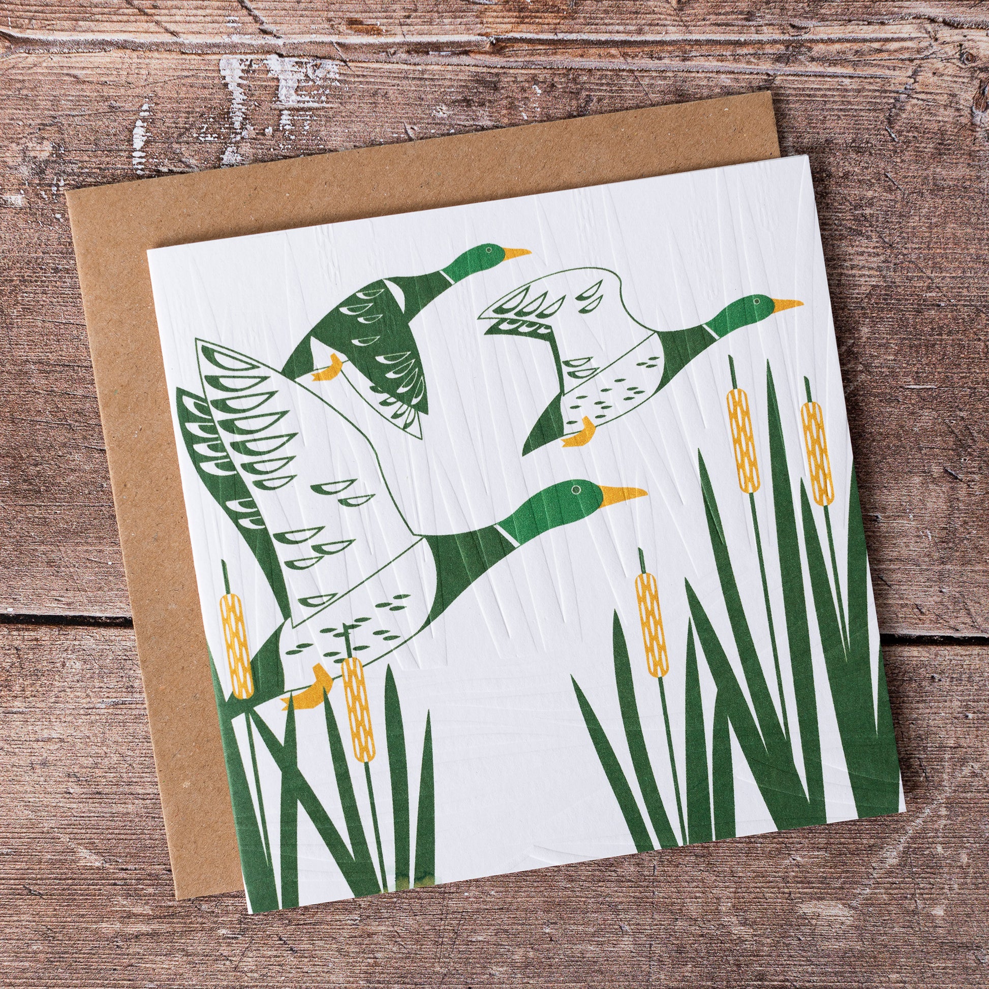 This high quality, linocut printed, Duck card has been handcrafted by the talented Ashley Hutchinson in his rural West Sussex garden studio.   This design features three ducks flying over reeds on an embossed card background.

